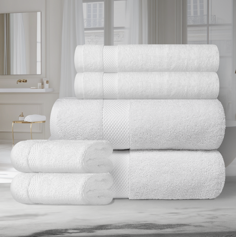 Stack of folded white Turkish cotton towels placed on a surface with a mirror and window in the background.